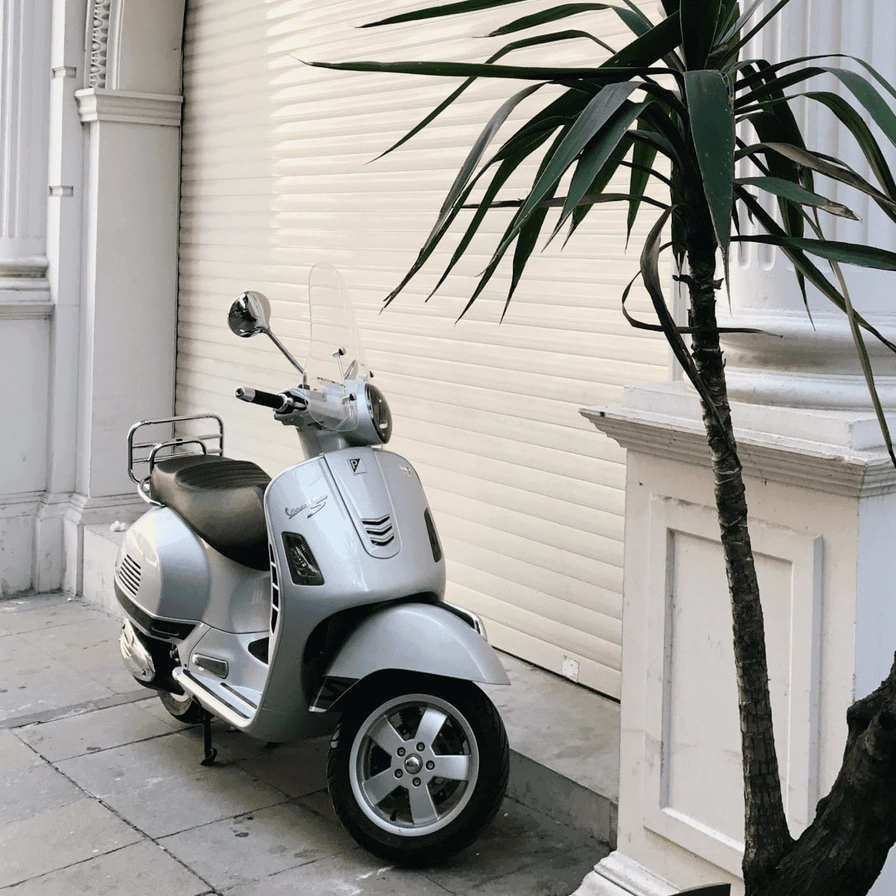 Motorroller, geparkt vor einer geschlossenen Garage