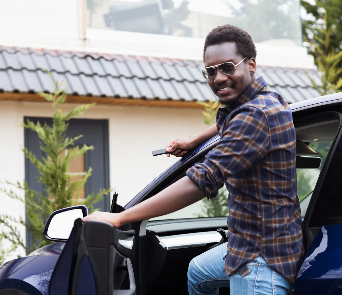 a Tracker GPS Pro in a man's hand as he gets into his car