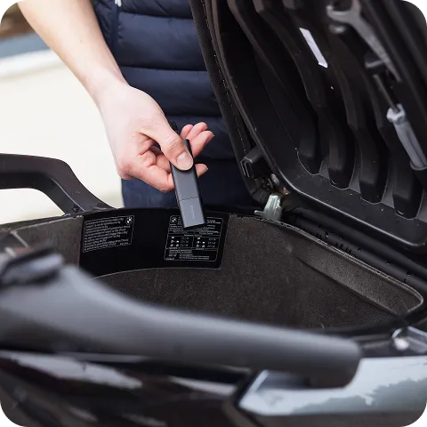 Ein Classic GPS Tracker, der im Kofferraum eines Rollers aufbewahrt wird