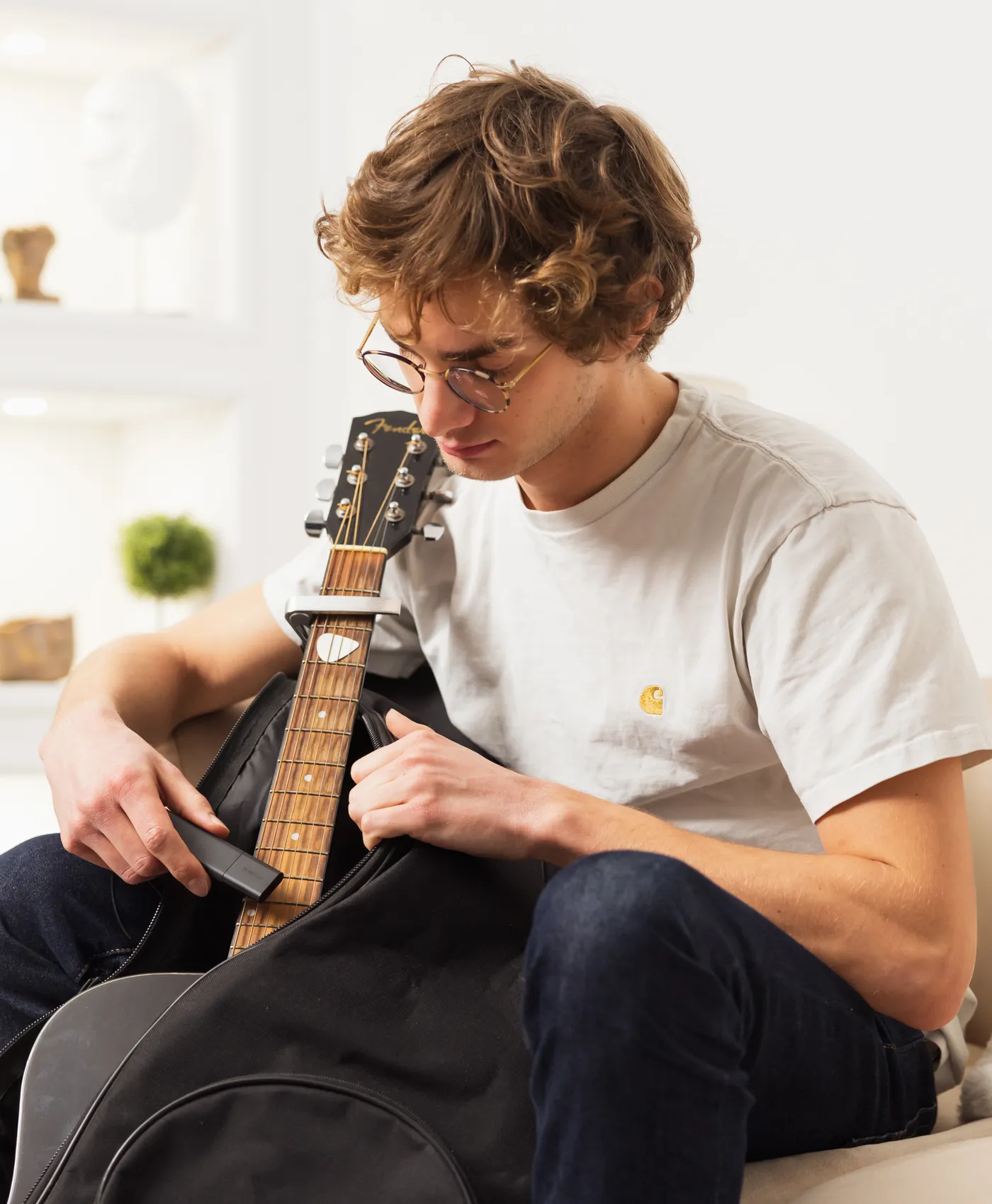 A young man hides a Classic GPS Tracker in a guitar case