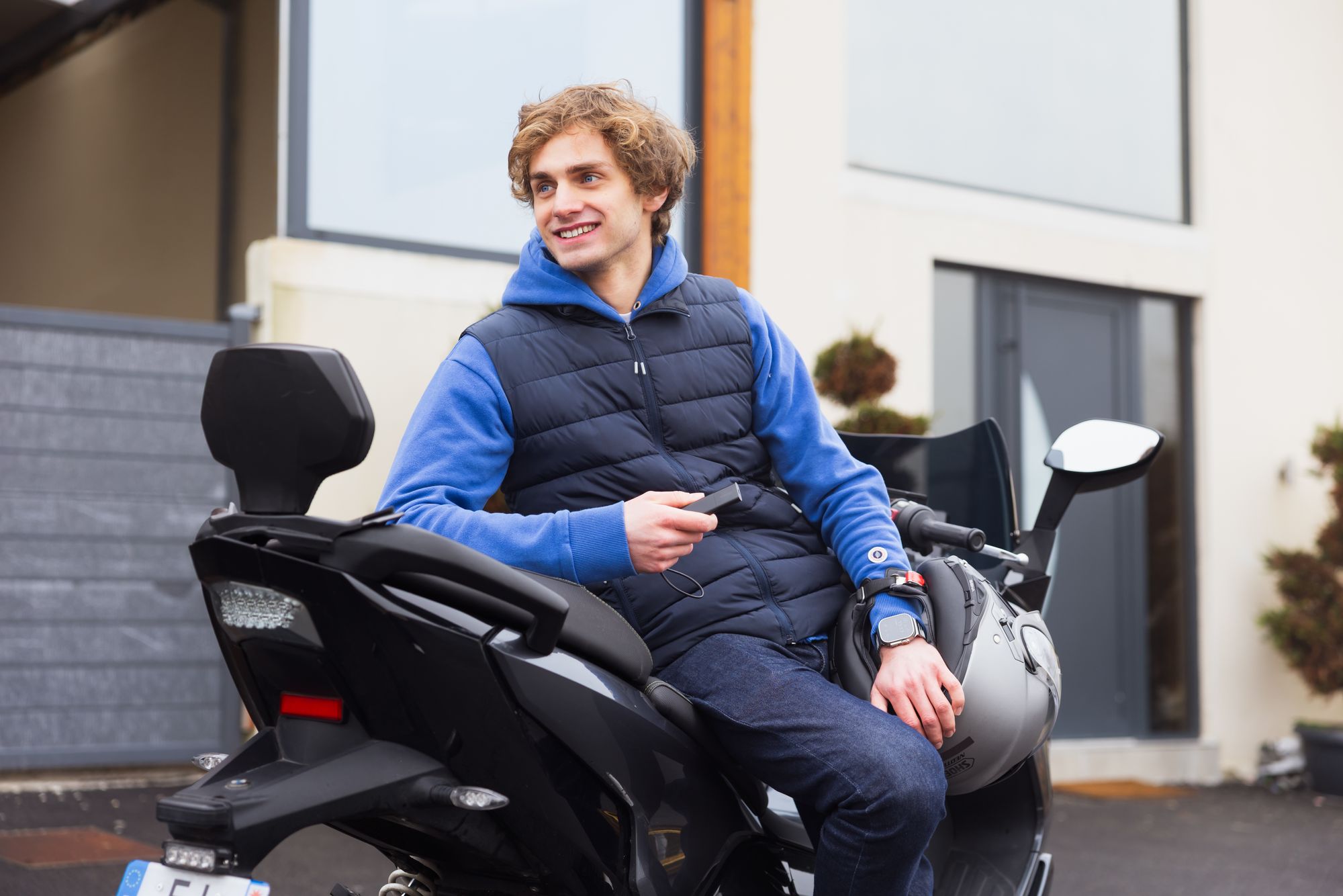 Man on scooter holding a GPS Tracker Pro in its hand